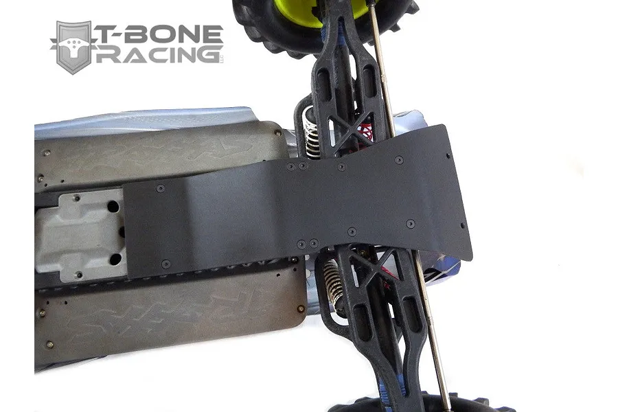 A T-Bone Racing black nylon chassis skid plate installed on the rear of an RC monster truck chassis against a white background.