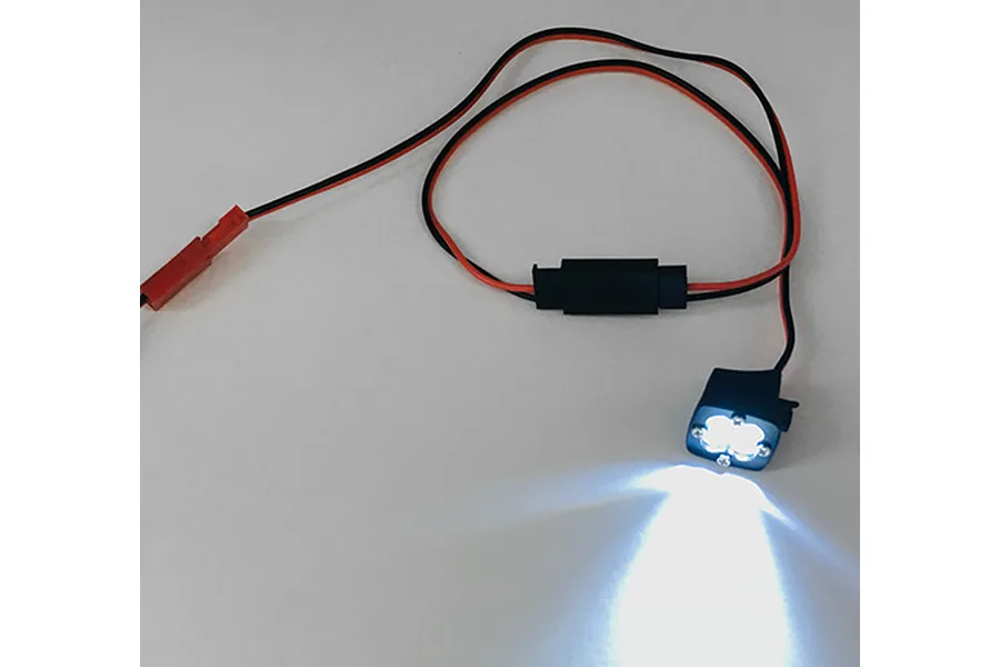 A Yeah Racing white LED light unit for RC crawlers, showing a square four-bulb lamp housing emitting a bright white light, connected by red and black wiring.