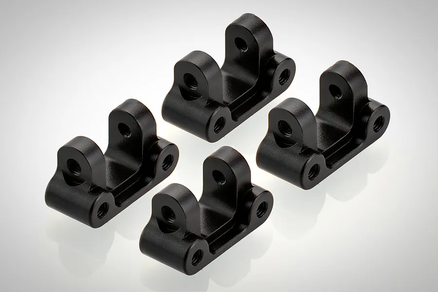 Four black aluminium RC linkage mounts arranged on a white background.