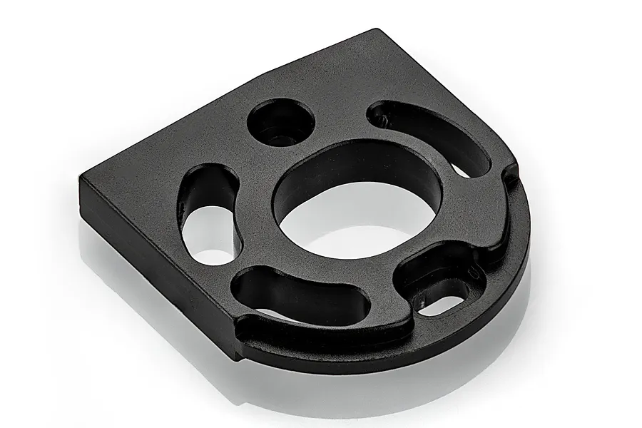 A black anodized aluminium motor mount for an RC car, featuring a central circular opening and curved mounting slots.