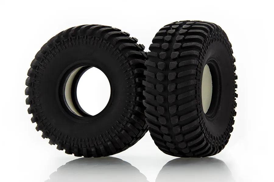 Two black rubber RC off-road tires with aggressive tread patterns and white foam inserts, standing upright on a white background.