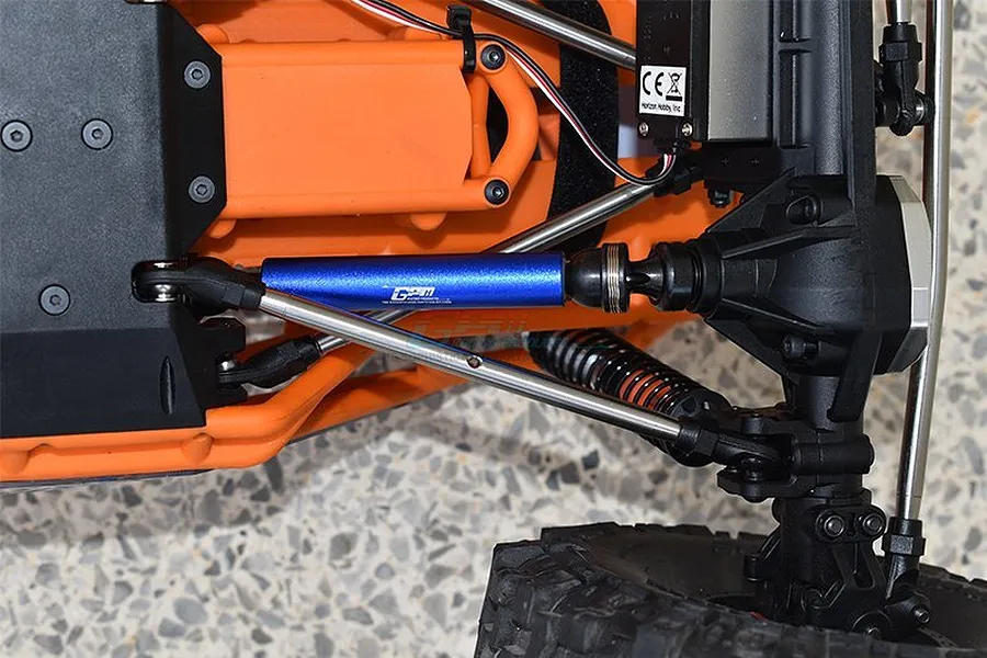 Close-up of a blue GPM aluminium drive shaft installed on an orange RC vehicle chassis.