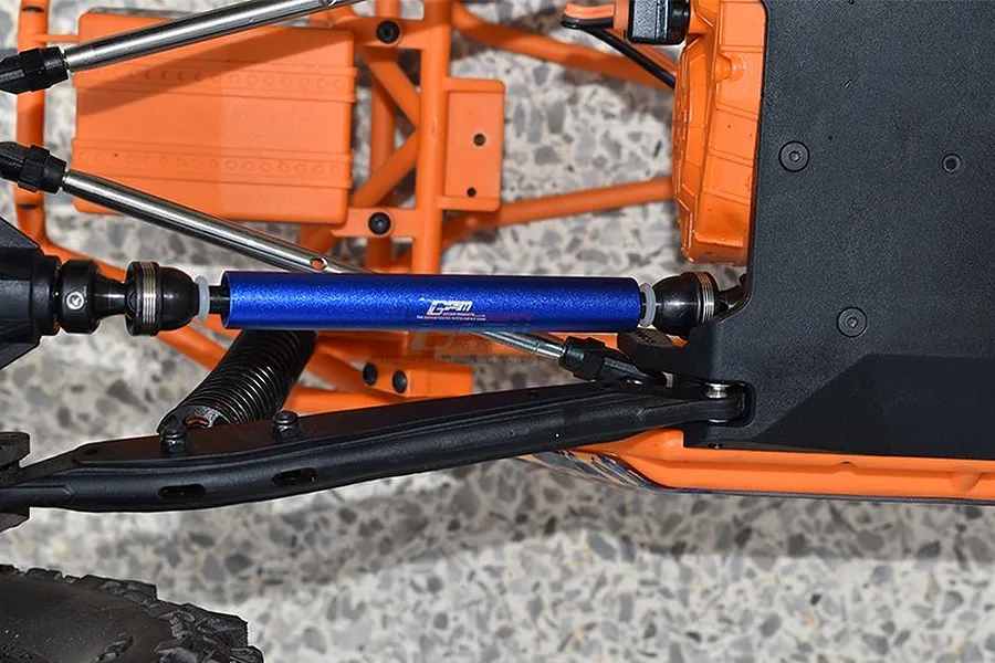 A blue GPM Racing aluminium drive shaft installed on an orange RC vehicle chassis.