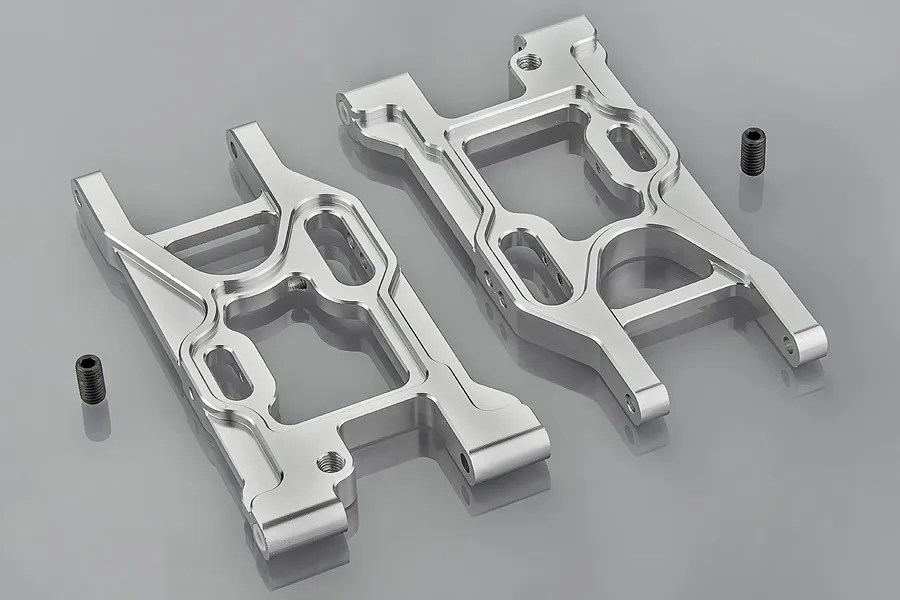 Two silver aluminium RC rear suspension arms with two small black grub screws on a grey background.