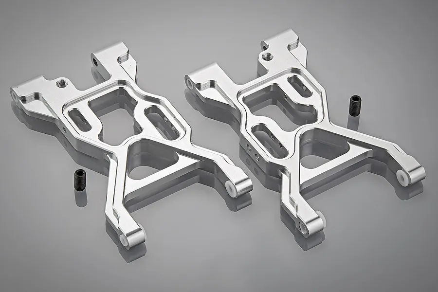 A pair of silver aluminium front suspension arms for an RC vehicle, shown on a grey background with two small black grub screws.