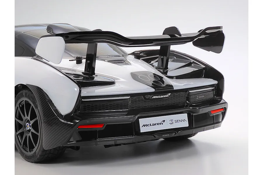 Rear view of a Tamiya McLaren Senna RC car model showing the large rear wing, taillights, and McLaren branding on a white background.