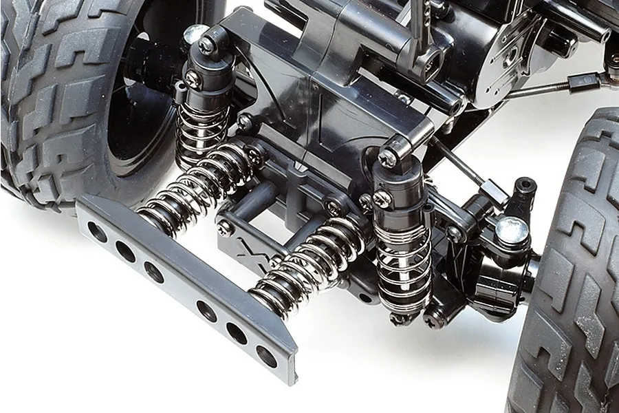 Close-up of the Tamiya GF-01 chassis suspension and front bumper assembly, showing coil-over shocks and black plastic components.