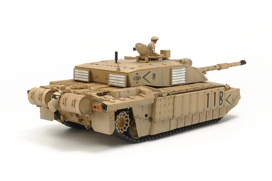 A fully assembled and painted 1/48 scale Tamiya British Challenger 2 tank model in desert camouflage with a crew figure in the hatch.