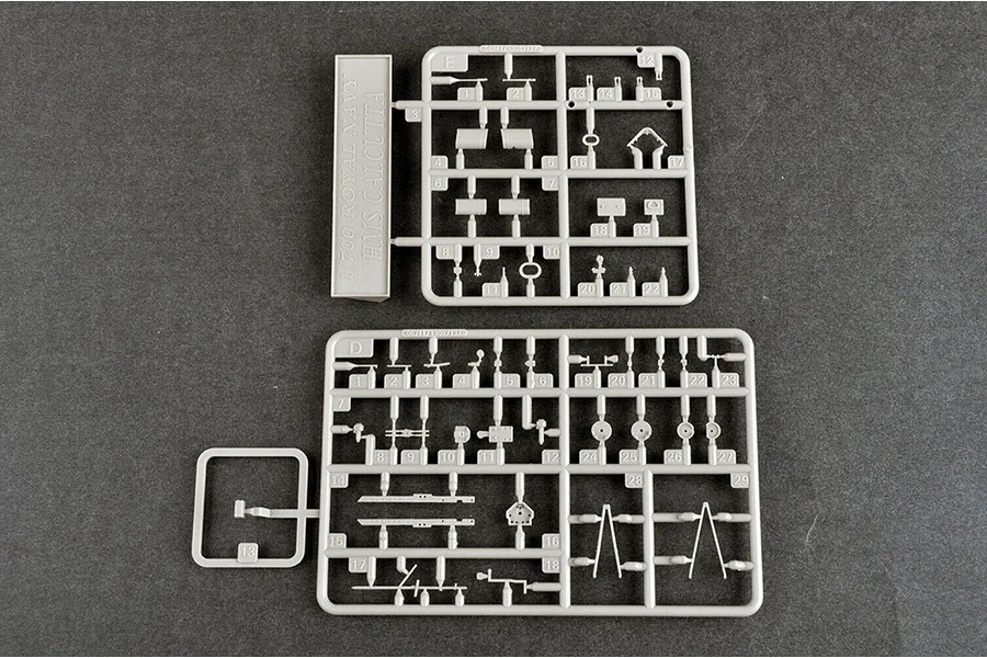 Two grey plastic model kit sprues labeled D and E for a 1/700 scale HMS Calcutta ship model, laid out on a dark grey surface.