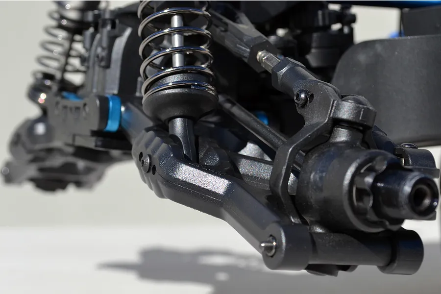 Close-up of a black RPM RC front suspension arm installed on an RC vehicle chassis with coil-over shock absorber.