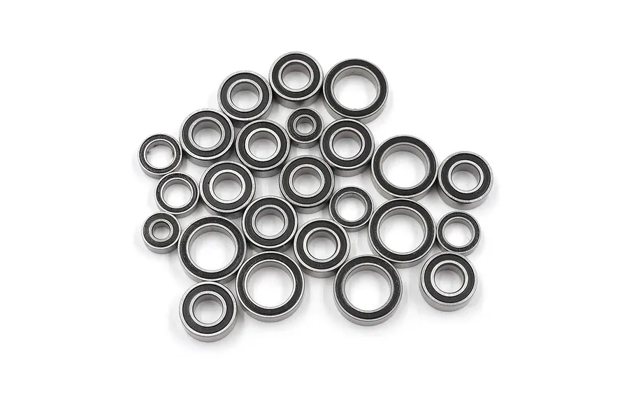A collection of various sized metal ball bearings with black rubber seals, arranged in a pile on a white background.