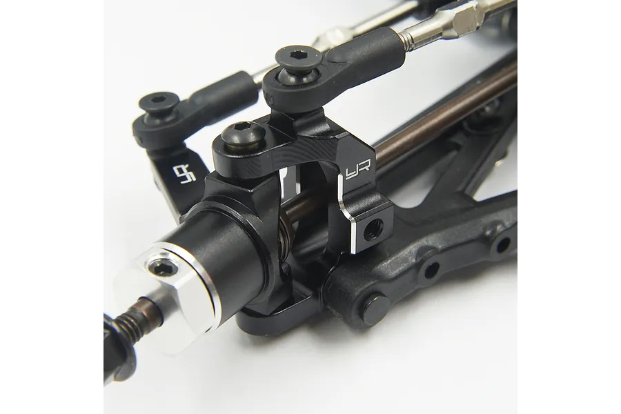 Close-up of a black anodized aluminum RC steering knuckle and suspension arm assembly with Yeah Racing branding.