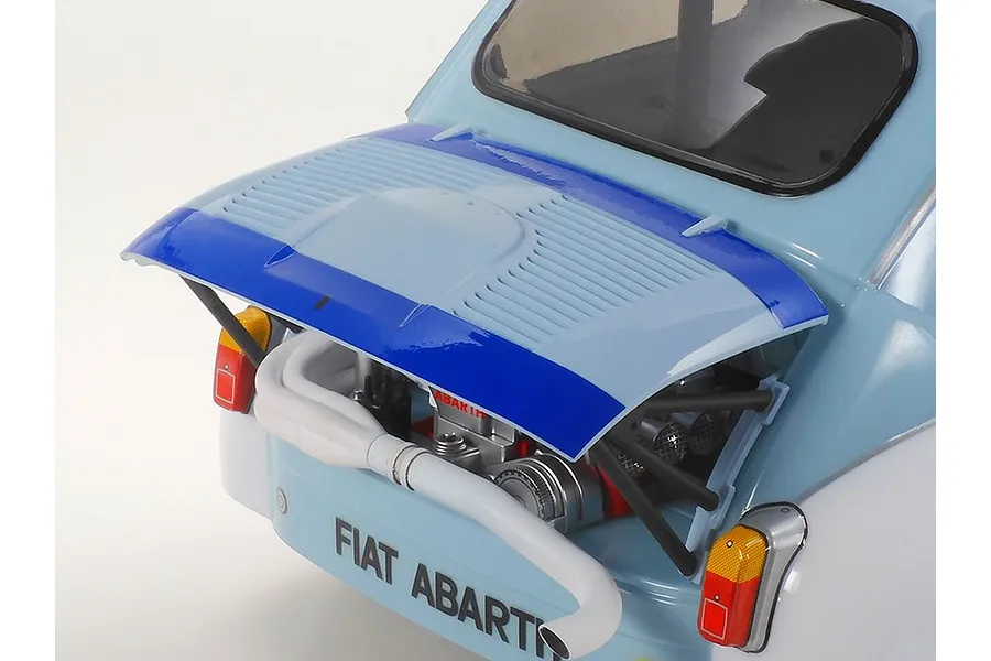 Close-up of the rear engine bay of a Tamiya Fiat Abarth 1000TCR RC car model with the engine cover propped open.