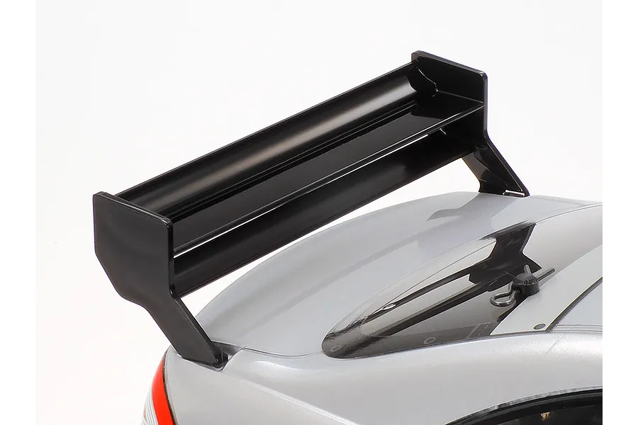 Close-up of the rear spoiler on a silver Tamiya Mercedes-Benz CLK-AMG RC car body against a white background.