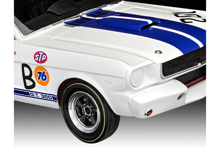 Close-up of the front quarter of a white 1966 Shelby GT 350 R model car with blue racing stripes and vintage racing decals.