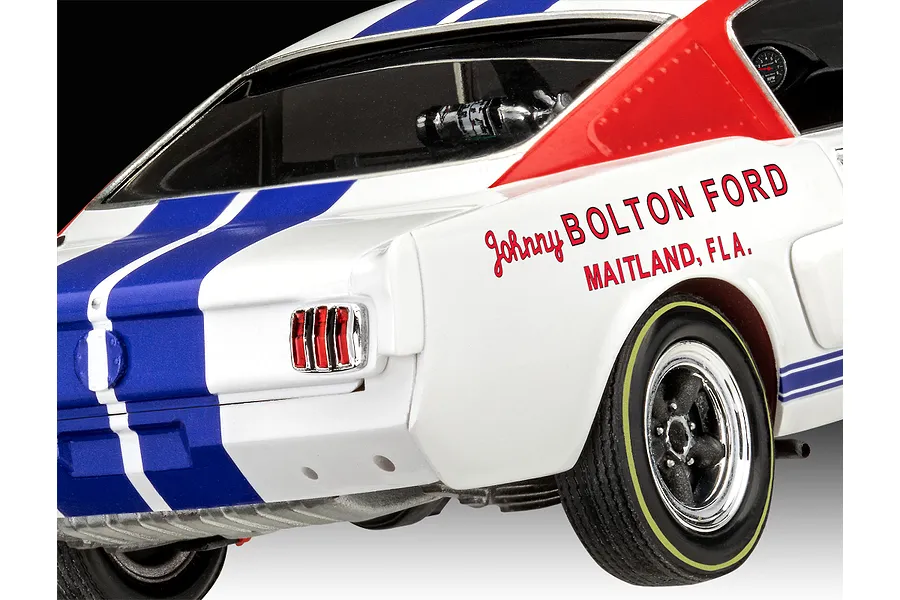 Close-up of the rear quarter of a white 1966 Shelby GT 350 R model car with blue racing stripes and Johnny Bolton Ford decals.