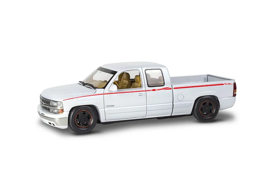 A white 1/25 scale model of a 1999 Chevy Silverado extended cab pickup truck with red side decals and black wheels.