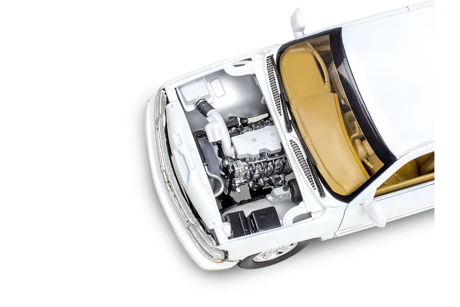 Top-down view of a white 1/25 scale model Chevy Silverado pickup truck with the hood open, revealing the engine bay and tan interior.