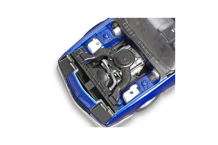 A high-angle close-up of the detailed engine bay of a blue 1/24 scale model Chevy Camaro Z28, showing the air cleaner, hoses, and engine components.