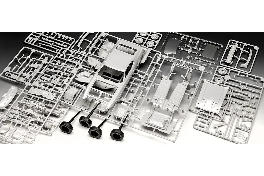 Plastic model kit sprues for a 1971 Ford Mustang Boss 351, including car body, chassis, interior parts, and four black rubber tires on a white background.