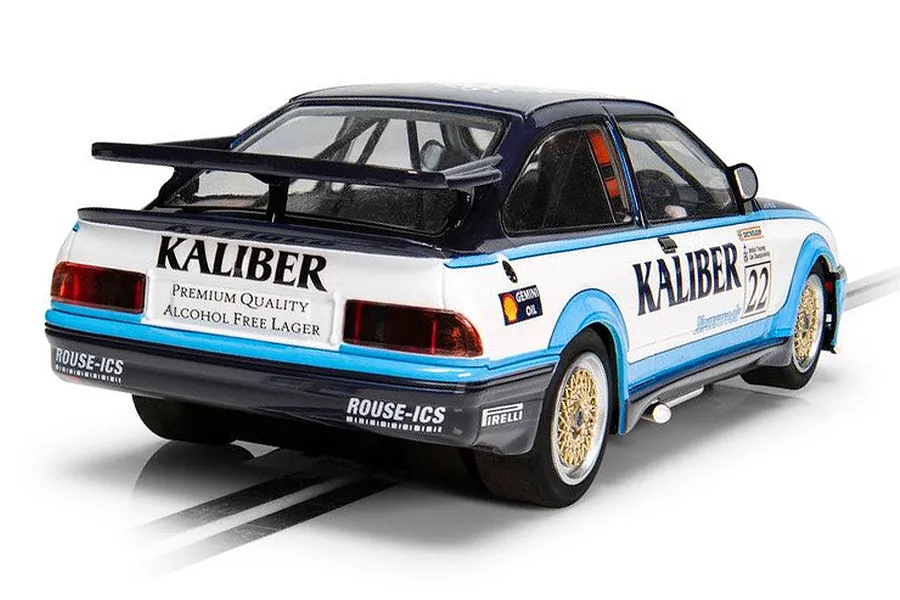 Rear three-quarter view of a Scalextric 1/32 scale Ford Sierra RS500 slot car in Kaliber livery on a track.