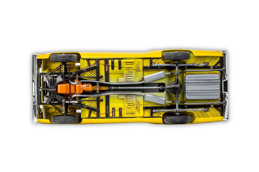 Underside view of a yellow 1970 Plymouth Roadrunner model car showing the chassis, engine, exhaust system, and fuel tank.