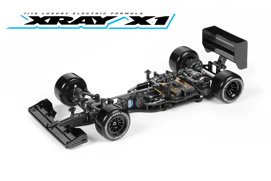 Studio shot of an XRAY X1 1/10 scale electric formula RC car kit on a white background, featuring a carbon fiber chassis and black wheels.
