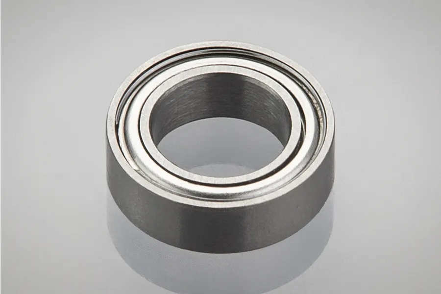 A single metal shielded ball bearing shown in a studio product shot against a light grey background.