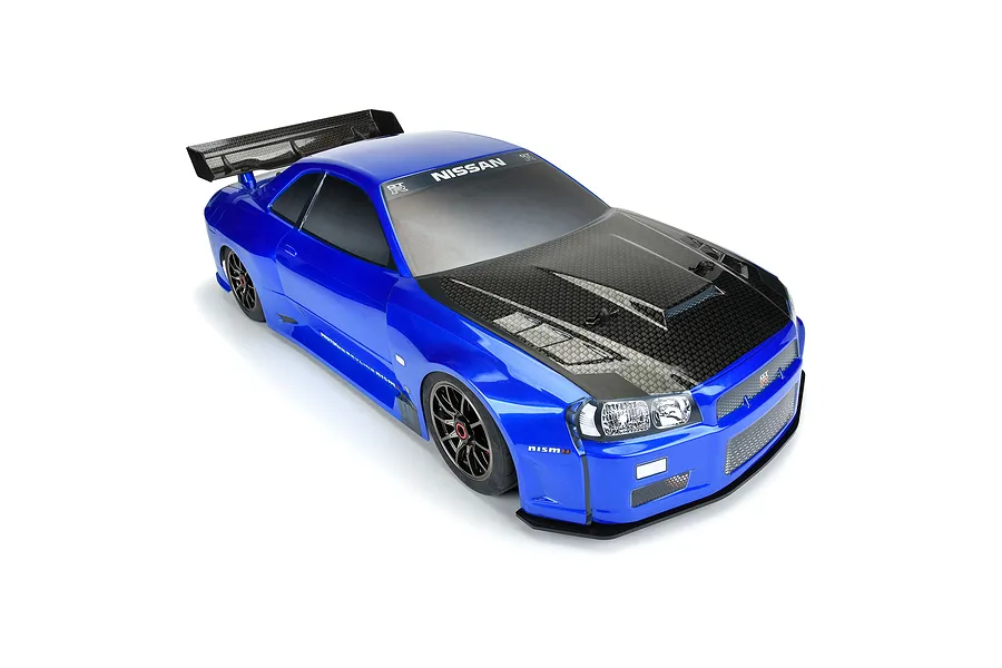 A blue Protoform 1/7 scale Nissan Skyline GT-R R34 RC car body shell with a carbon fiber look hood and rear wing, shown on a white background.