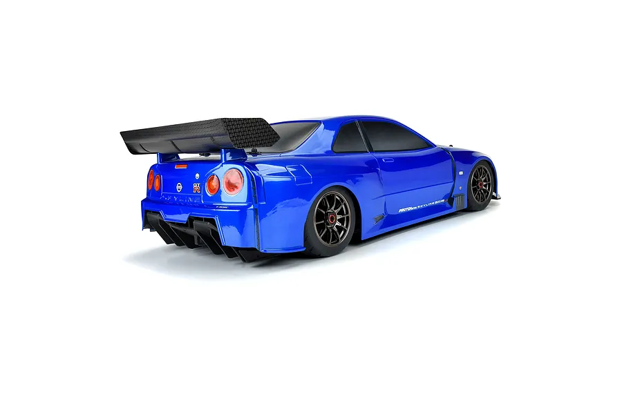 Rear three-quarter view of a blue RC Nissan Skyline GT-R R34 body shell with a large black rear wing and detailed taillights on a white background.