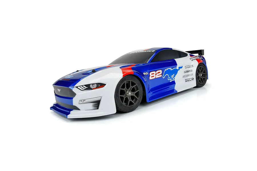 A pre-painted blue, white, and red Protoform 2021 Ford Mustang RC body shell mounted on a chassis with black wheels, viewed from a front three-quarter angle.
