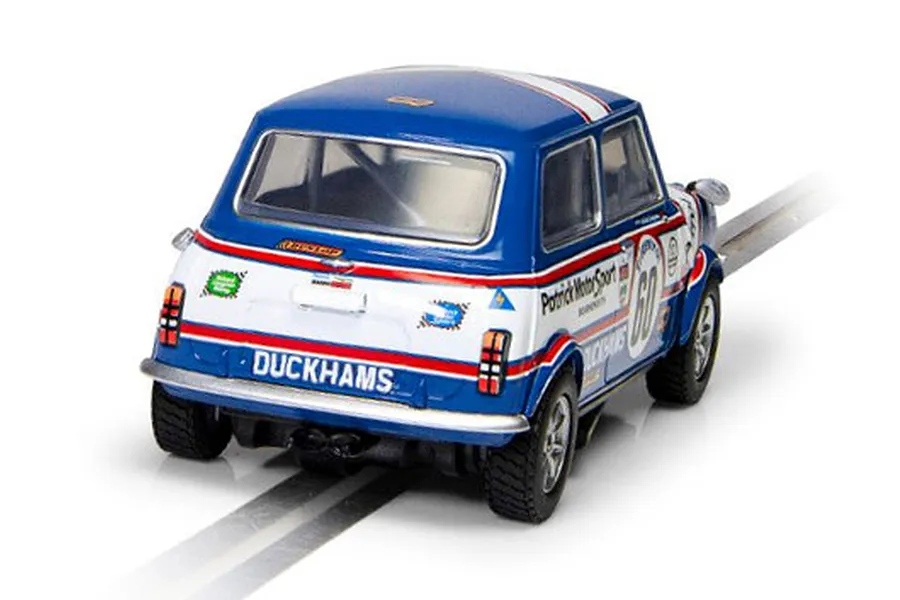 Rear three-quarter view of a blue and white Scalextric Mini 1275GT slot car with Patrick Motorsport livery on a track.