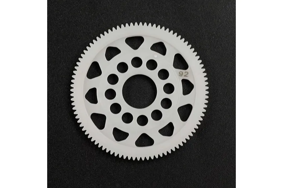 A white Delrin 92T spur gear for RC cars, featuring a circular design with weight-reduction holes and the number 92 printed on the face.