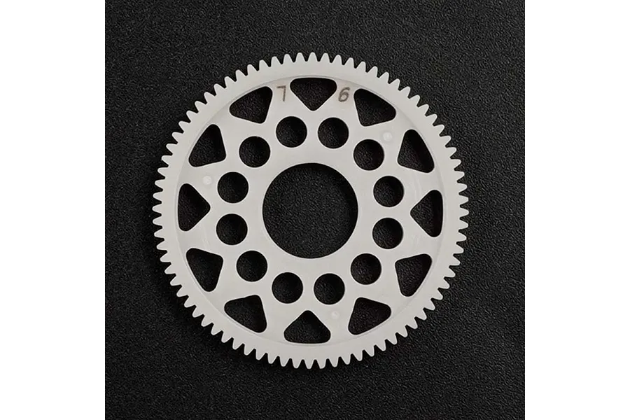 A white Delrin spur gear with 76 teeth and 64dp pitch, featuring a lightweight design with circular cutouts, set against a black textured background.
