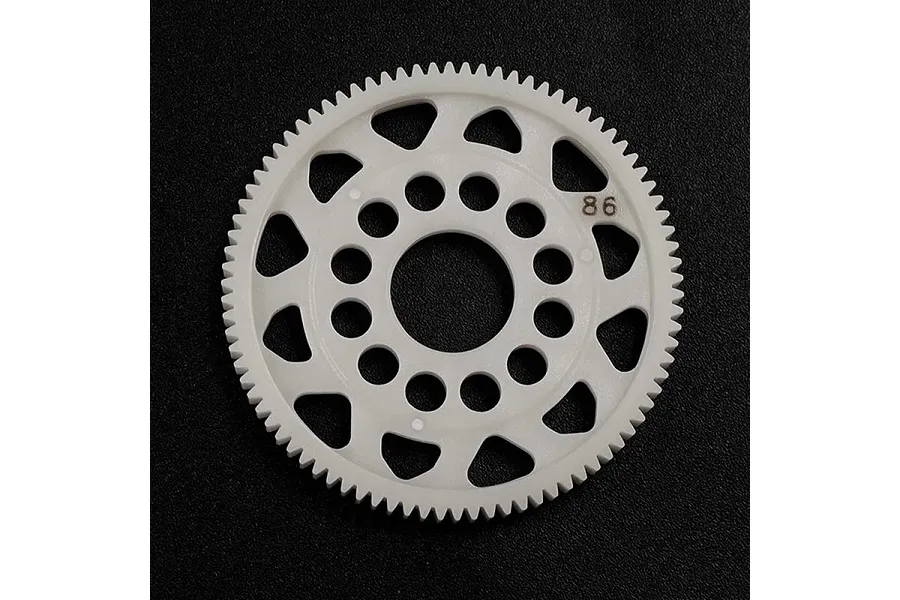 A white Delrin 86T spur gear for RC cars, featuring a circular design with multiple cutouts and the number 86 printed on the face.
