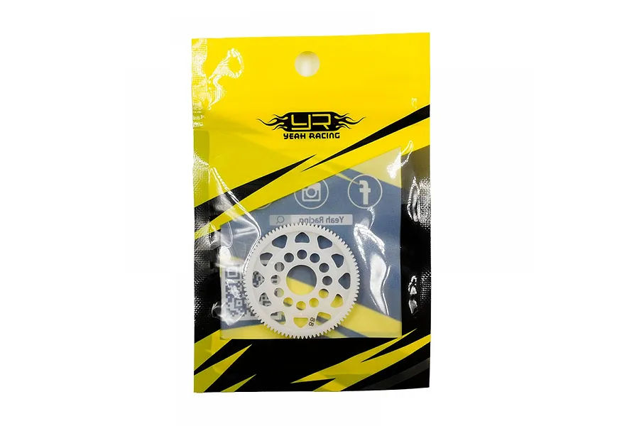 A white Delrin spur gear in its original Yeah Racing yellow and black plastic packaging.