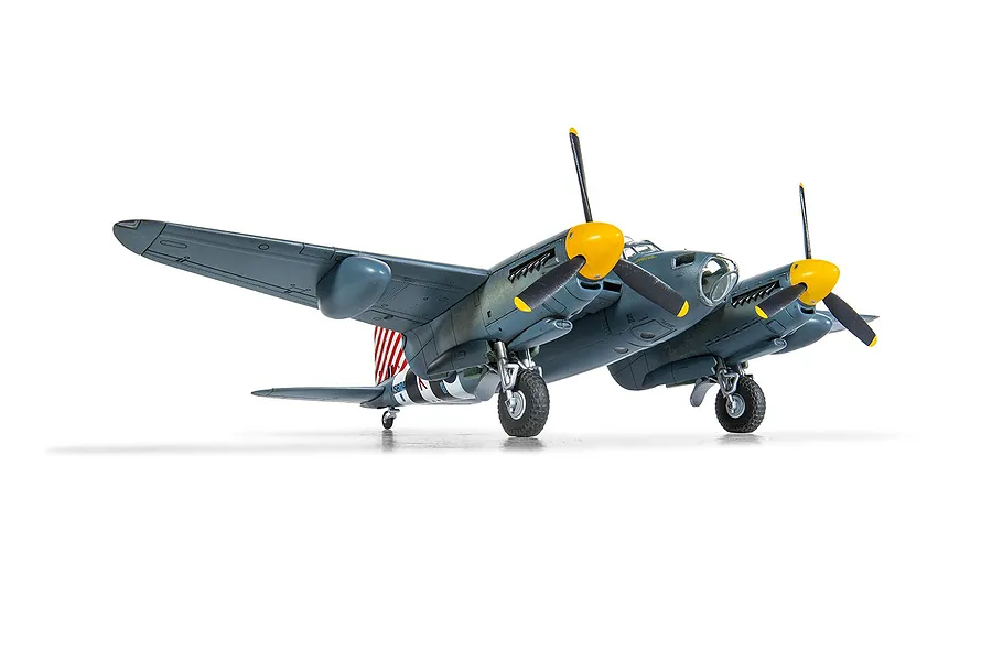 A completed 1/72 scale plastic model kit of a de Havilland Mosquito aircraft, painted in grey with yellow propeller spinners, shown from a front-quarter angle.