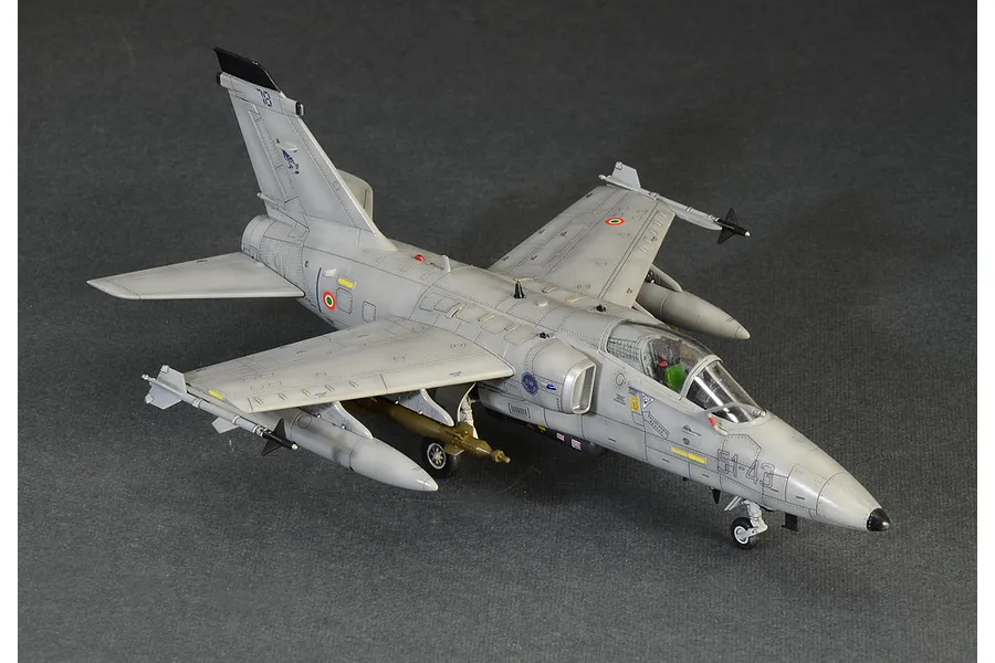 A high-angle view of a completed 1/72 scale Italeri AMX Ghibli model aircraft, painted in grey with Italian Air Force markings on a dark grey background.