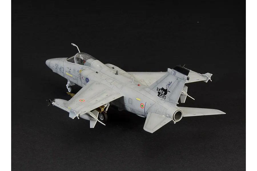 A completed 1/72 scale plastic model of an AMX Ghibli attack aircraft, painted in light grey with Black Cats squadron markings on a black background.