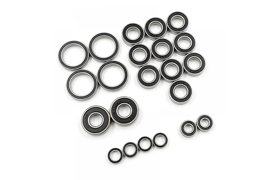 A collection of various sized rubber shielded ball bearings arranged on a white background.