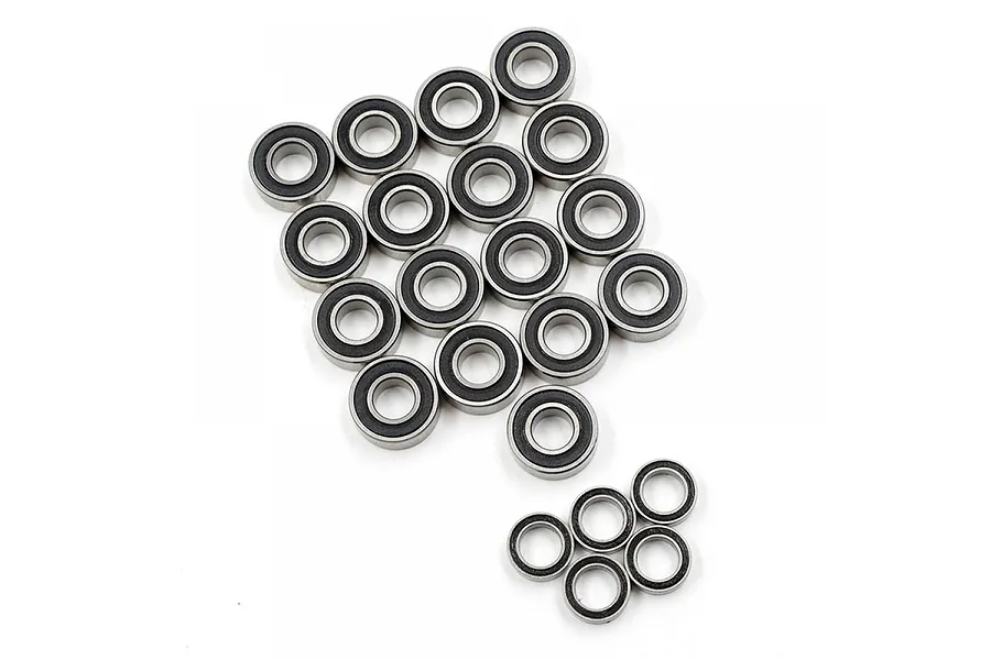 A collection of various sized metal ball bearings with black rubber seals arranged on a white background.