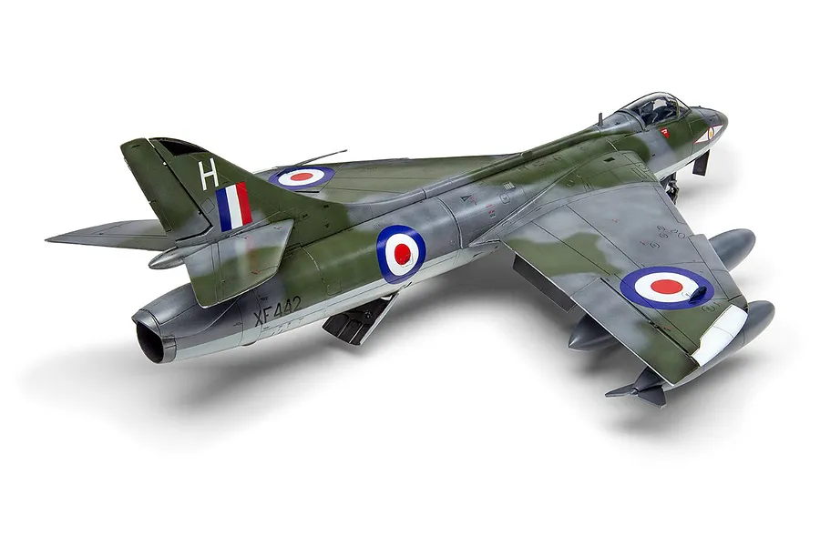 A completed 1/48 scale plastic model of a Hawker Hunter fighter jet, painted in a green and grey camouflage scheme with RAF markings.