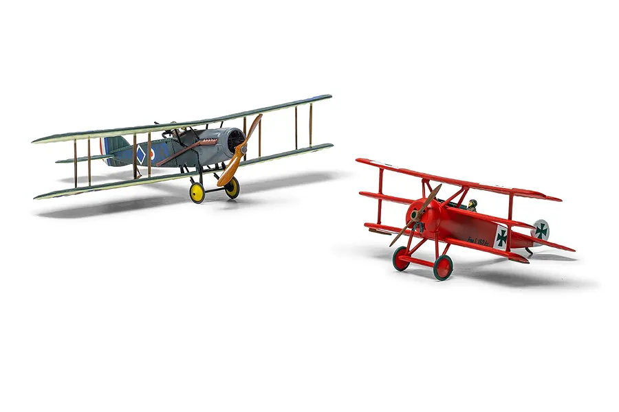 Two assembled and painted 1/72 scale model aircraft, a grey Bristol F.2B and a red Fokker Dr.1 triplane, displayed on a white background.