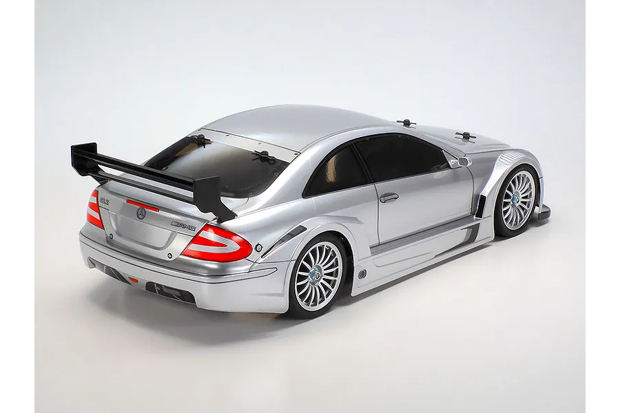 Rear three-quarter view of a silver Tamiya Mercedes-Benz CLK-AMG RC touring car on a white background.