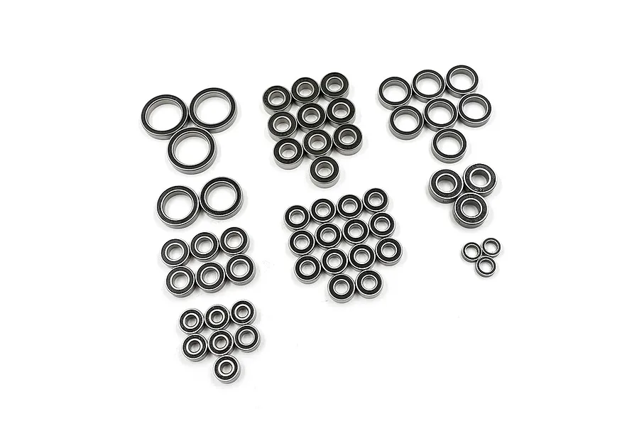 A collection of various sized rubber shielded ball bearings arranged in groups on a white background.