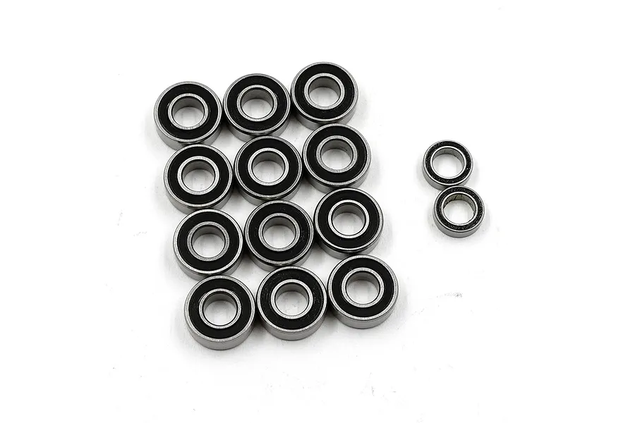 A collection of twelve metal ball bearings with black rubber seals arranged on a white background.