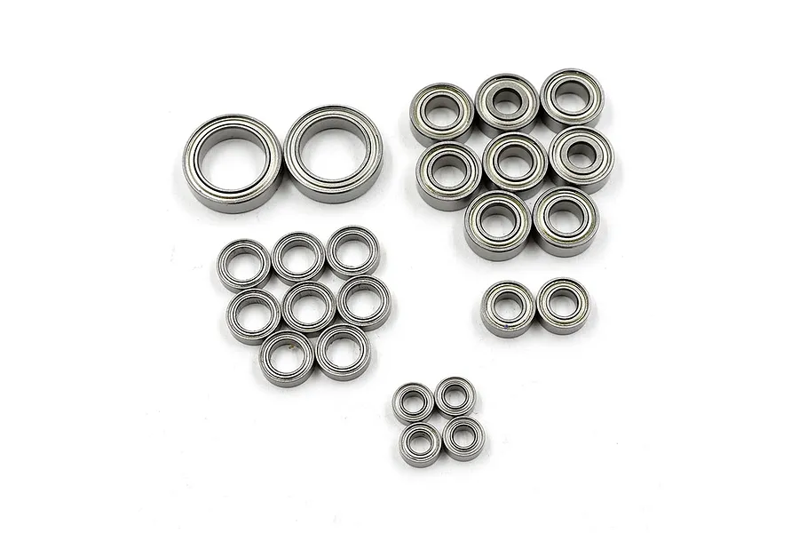 A collection of various sized metal shielded ball bearings arranged on a white background.
