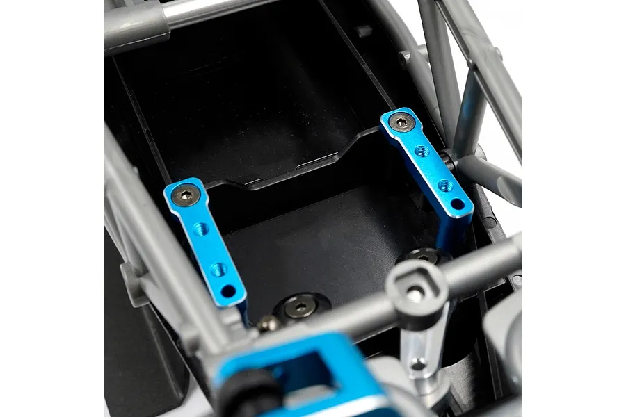 Two blue anodized aluminium servo mounts installed on a black RC chassis frame.