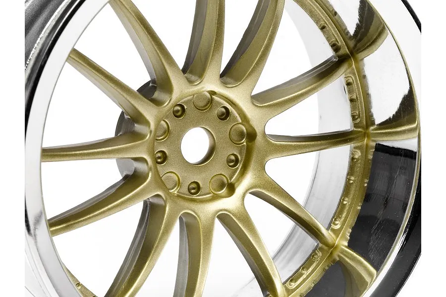 Close-up of a gold and chrome RC car wheel rim with a multi-spoke design against a white background.
