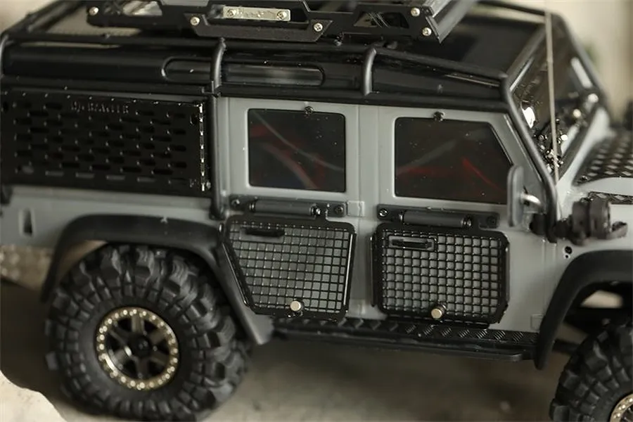 Close-up of a grey RC crawler vehicle featuring black metal window guards installed on the side doors.